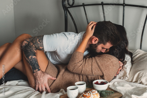 Passionate young couple with breakfast in bed photo