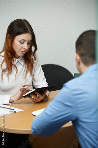 Woman with tablet consults man