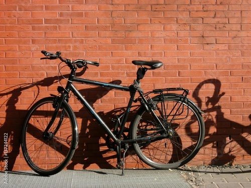 Modernes schwarzes Trekkingrad für Herren vor einer braunen Backsteinfassade bei Sonnenschein im Hansaviertel oder Hafenviertel am Kreativkai am alten Hafen von Münster in Westfalen im Münsterland