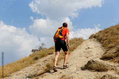 Vászonkép Man walking up steep mountain