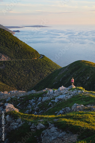 Hiker on rocky outcrop, Cape Breton, Nova Scotia, Canada