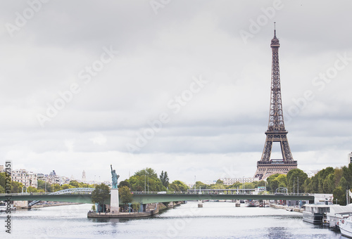 Eiffel Tower, Seine river and Statue of Liberty in Paris, France. Boats on Seine river. © Kotkoa