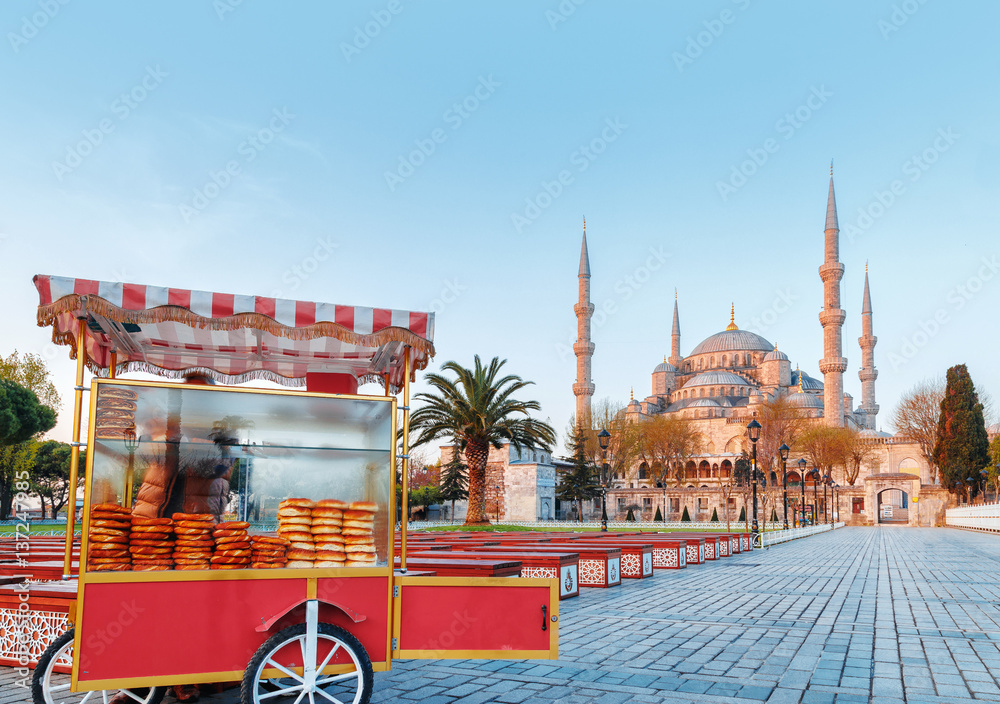 Fototapeta premium Traditional turkish fast food cart at Blue Mosque Cami background. Morning scene. Classical Istanbul city center scenery, Turkey.