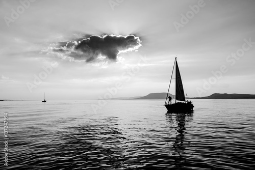 A little boat is sailing on the water with captain on board