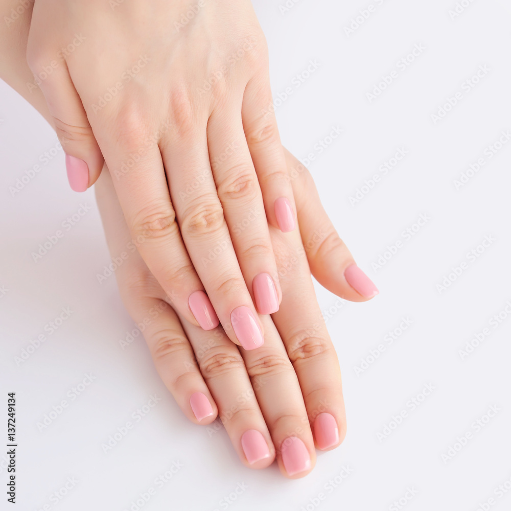 Closeup of hands of a young woman with pink manicure on nails