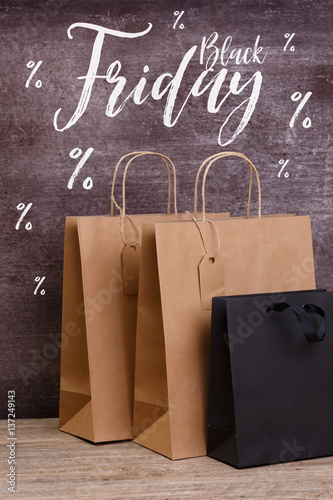 Mockup of blank shopping bags. Black friday sale. Brown and black craft packages. Concept for sales or discounts. Recycled paper. Wooden rustic board.
