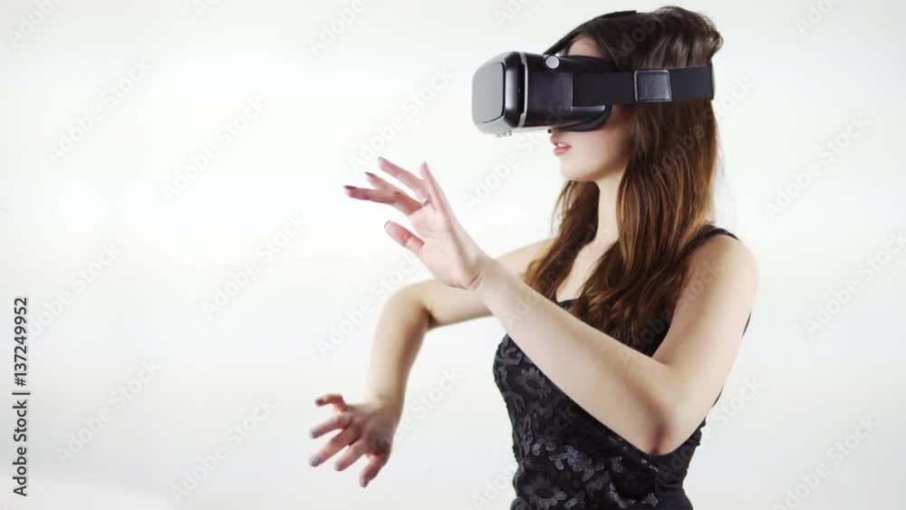 Young woman using a virtual reality glasses isolated on a white background Young woman using a virtual reality glasses isolated on a white background