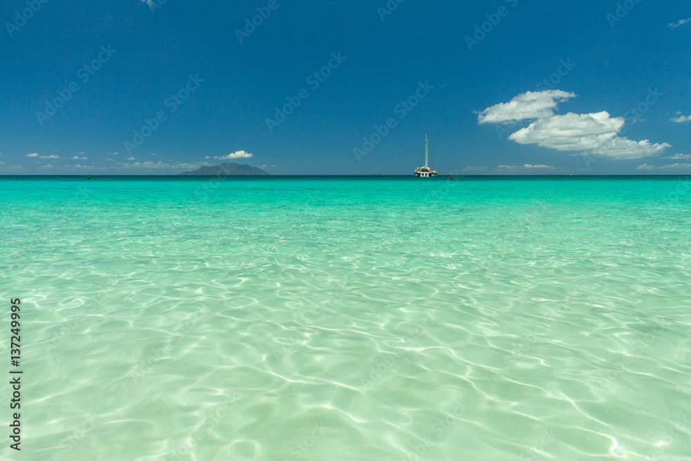 Seychelles. Transparent turquoise water and blue sky on the background.