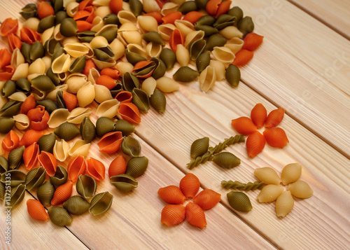 Assortment of colorful pasta in  on wooden background
