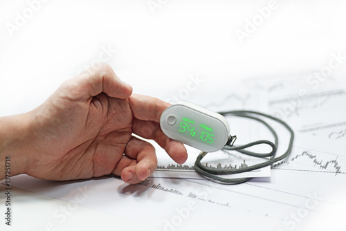 Blood oxygen meter on mans finger. photo