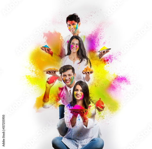 good looking indian people celebrating holi festival with mobile phones, colours, sweets and pichkari, isolated over white background