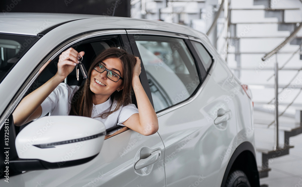 Young happy woman near the car with keys in hand Young happy woman near the car with keys in hand