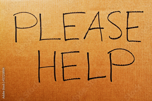 The words "Please Help" written on a carboard sign