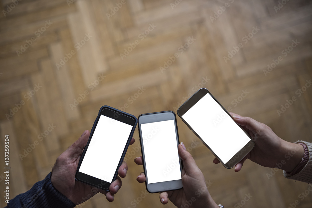 Obraz premium Three hands holding smart phones