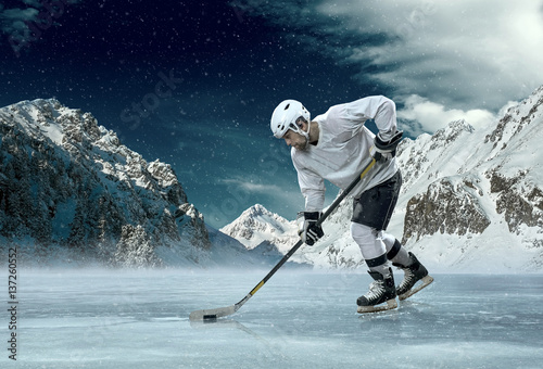 Photography Ice hockey player in action outdoor around mountains