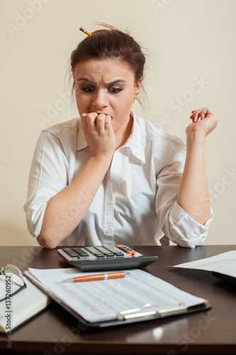 Frightened accountant looks at the balance sheet photo