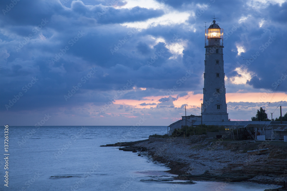 blue twilights around old lighthouse on the sea coast