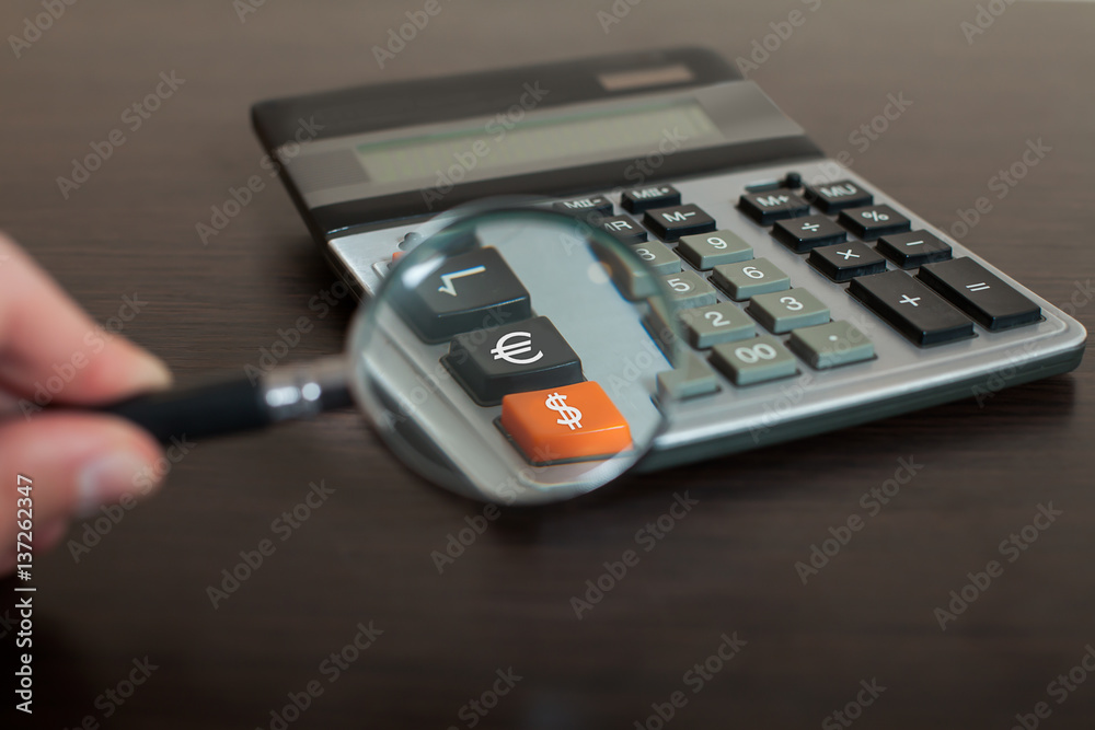 Obraz premium Looking through magnifying glass on calculator