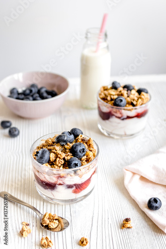 Morning granola with yogurt and berries on white kitchen background