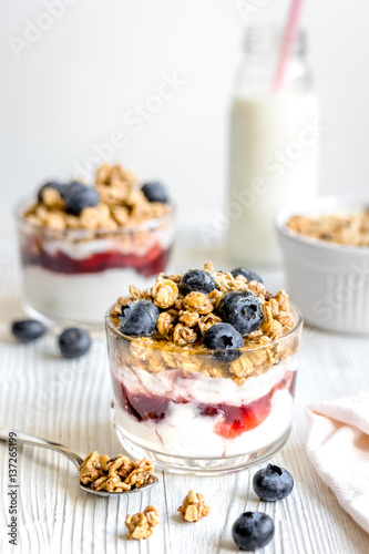 Homemade fitness granola with yoghurt and berries on white kitchen background