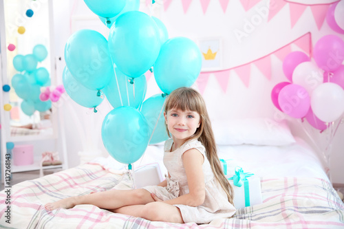 Cute girl with balloons sit...