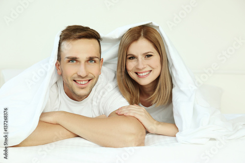 Young cute couple in bed un...