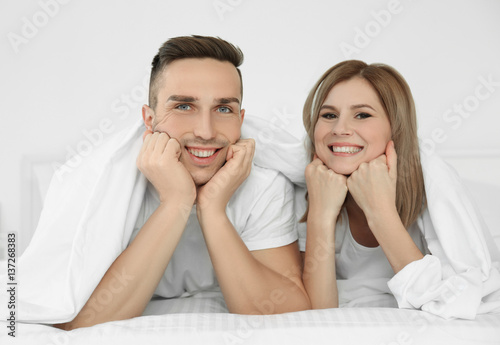 Young cute couple in bed under sheet