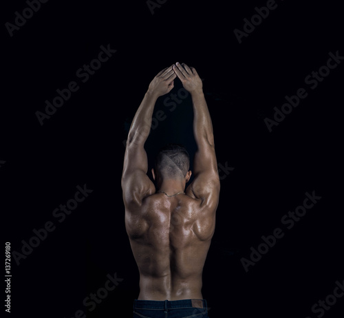Young attractive handsome muscular sexy bodybuilder back with raised hands
