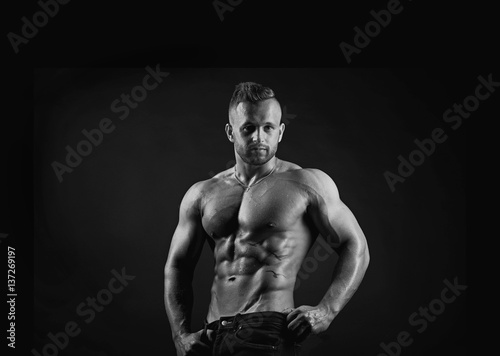 Attractive sporty handsome sexy muscular young adult male fitness model in black and white portrait