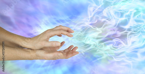 Sensing Ectoplasm Activity - female hands cupped sensing a gaseous field of ectoplasmic matter on a  blue background with copy space 