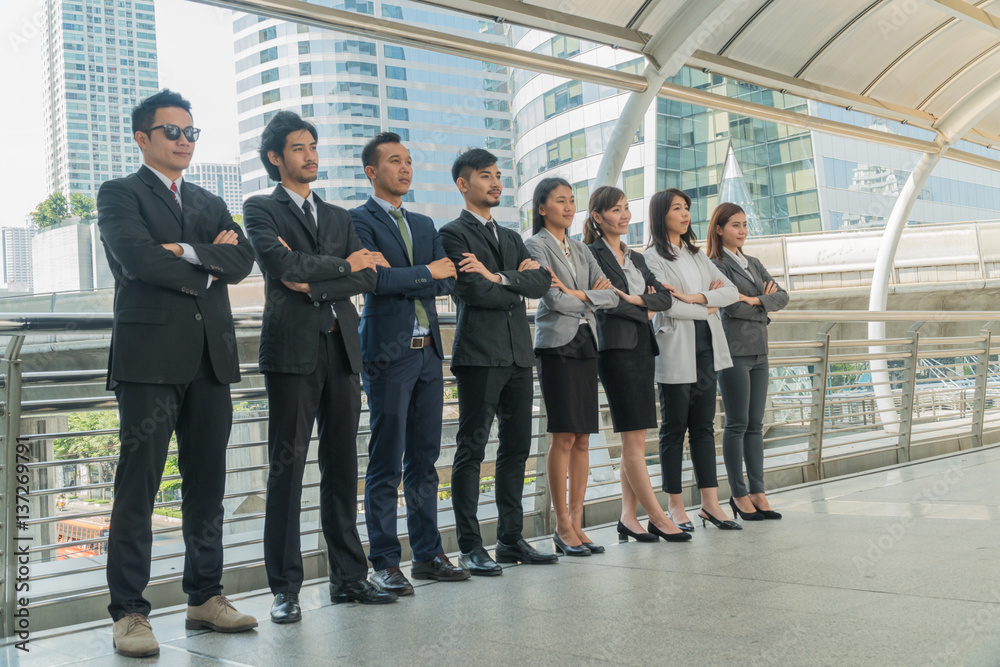 Team businessman standing arms crossed in the city. Team businessman standing arms crossed in the city.