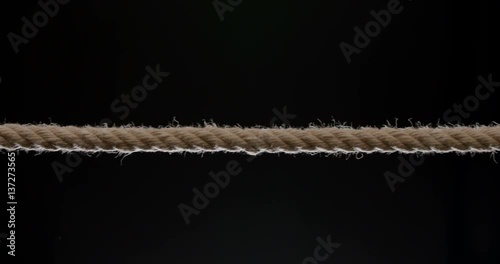 Medium shot of rope being pulled across the frame