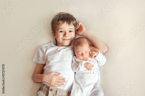 Papier peint Little brother hugging her newborn baby