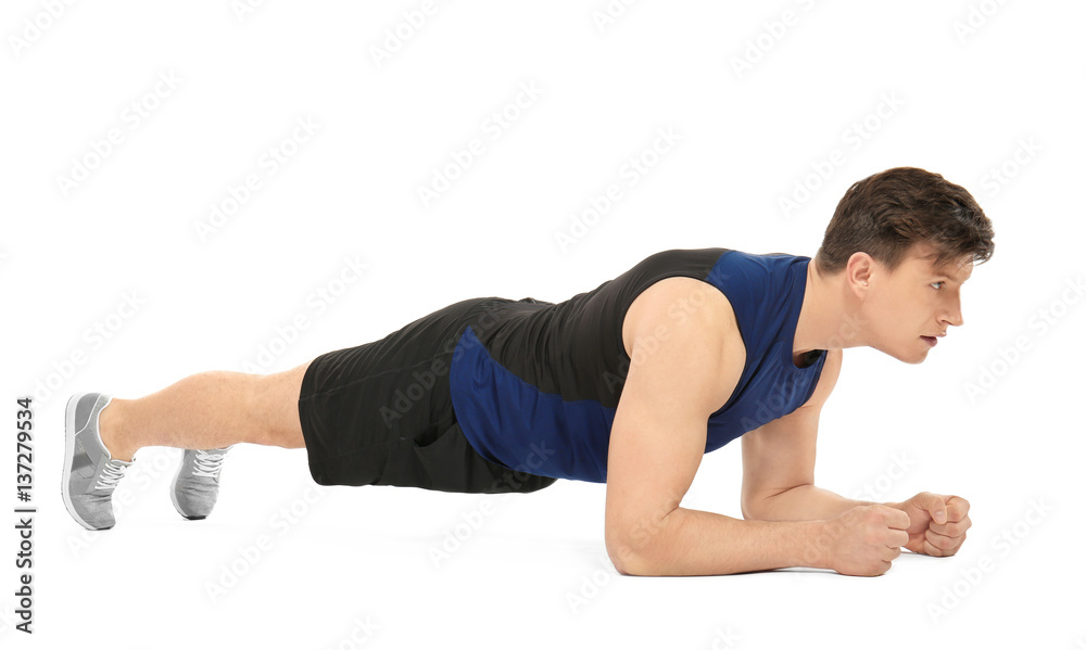 Young handsome sportsman doing exercises on white background