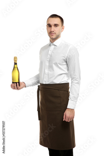 Young handsome waiter holding wine bottle on white background