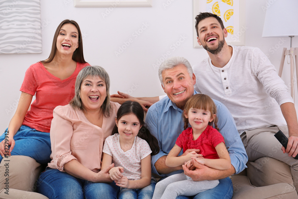 Happy family watching TV on sofa at home Happy family watching TV on sofa at home