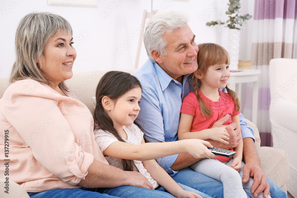 Happy family watching TV on sofa at home Happy family watching TV on sofa at home