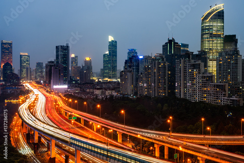 light trails on city street with cityscape at night in China.