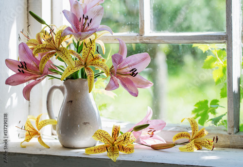 Fototapeta Naklejka Na Ścianę i Meble -  lilies bouquet on a window sill in a sunny  day
