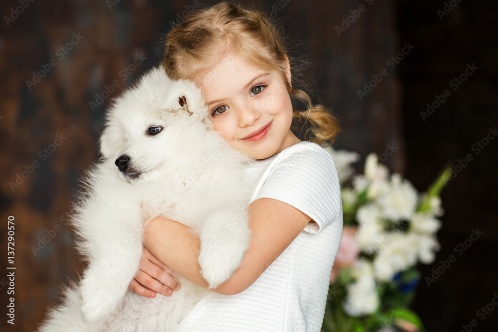 Little girl with a samoyed puppy Little girl with a samoyed puppy