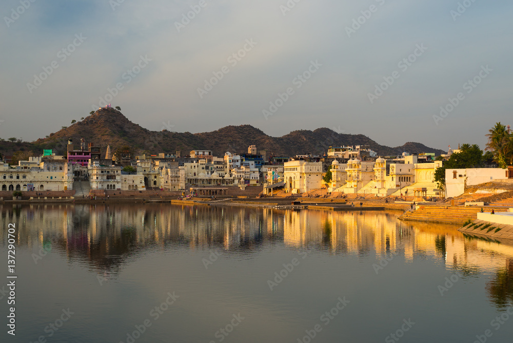 Cityscape at Pushkar, Rajasthan, India. Temples, buildings and ghats reflecting on the holy water of the lake at sunset.