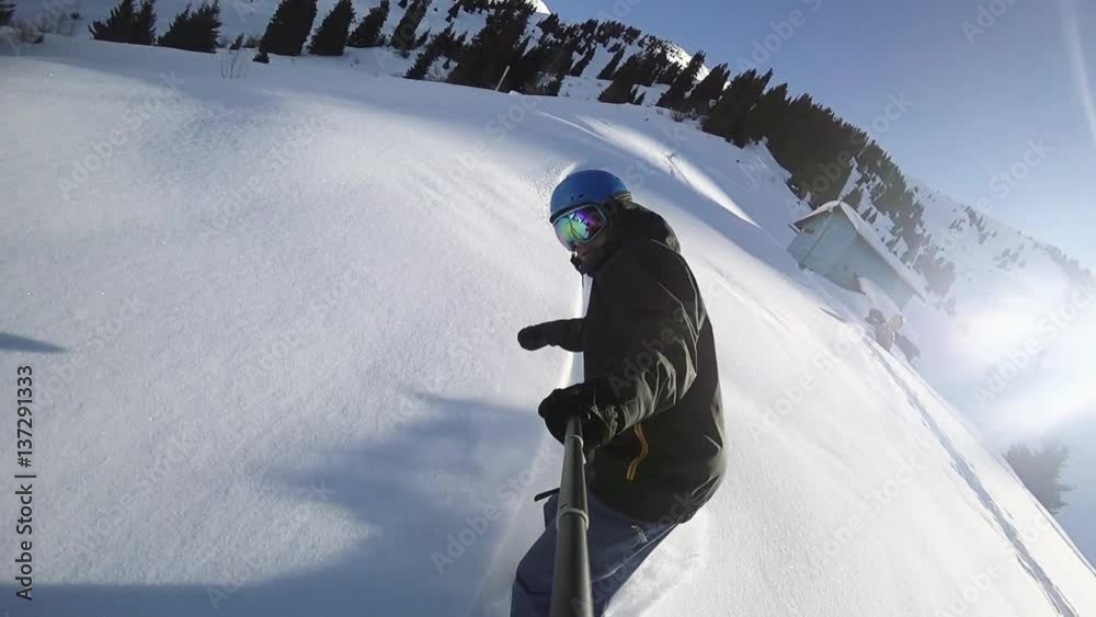 Close up of extreme snowboarder riding by powder by GoPro