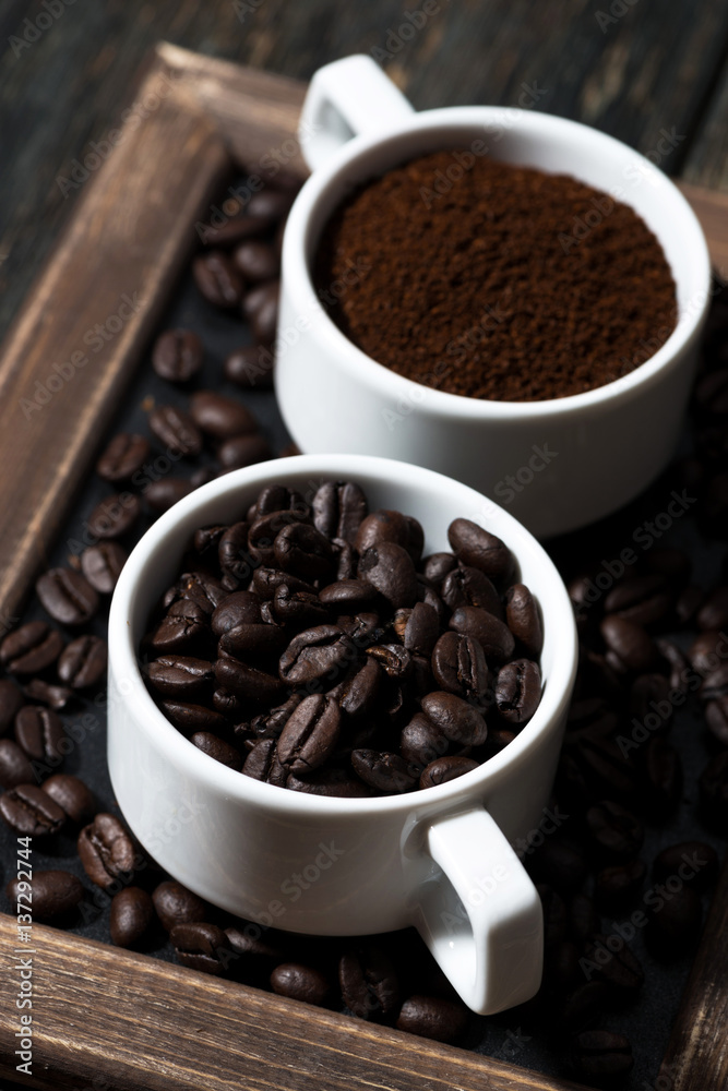 ground coffee and coffee beans in cups, vertical closeup ground coffee and coffee beans in cups, vertical closeup