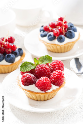 mini tarts with cream and berries, vertical