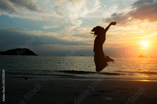 silhouette women jumping on the beach seaside.