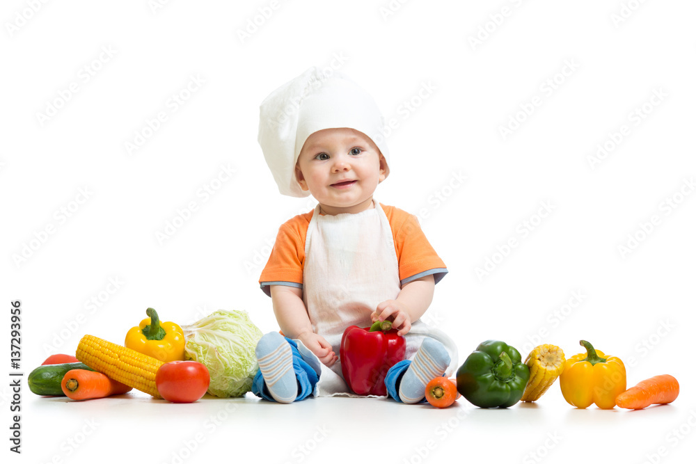 Smiling chef kid boy with vegetables isolated on white background Smiling chef kid boy with vegetables isolated on white background