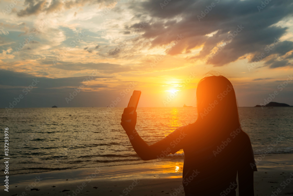 silhuoette women selfie and sunset on the beach seaside.