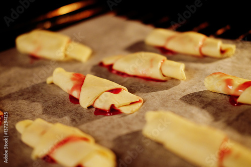 Freshly made croissants with jam inside the oven photo