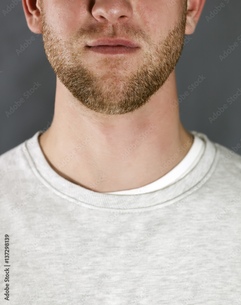 Fototapeta premium Portrait of the young smiling man on gray background, Cropped image 
