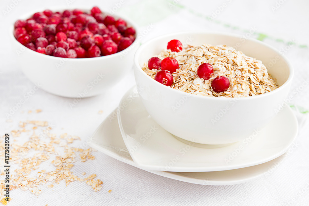 Rolled oats, porridge and cranberries for a healthy breakfast in a rustic style Rolled oats, porridge and cranberries for a healthy breakfast in a rustic style